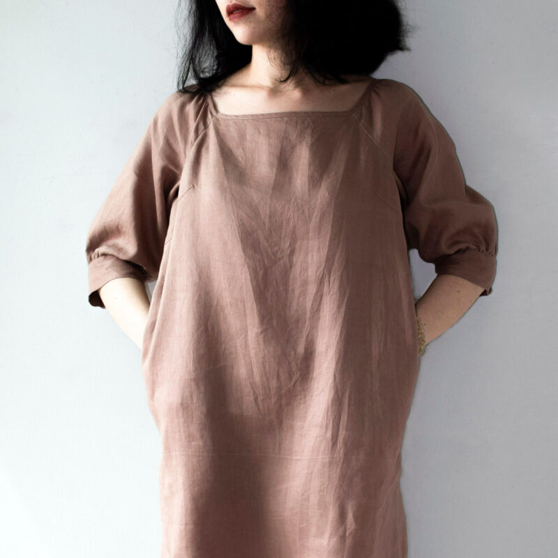 Crafted from breathable 100% linen, this earthy brown dress features a square neckline and raglan sleeves, creating a naturally elegant silhouette. The mid-length cut offers a timeless charm, while the relaxed fit gently flows with your body for effortless summer comfort. A simple yet refined piece for lovers of minimalist fashion.