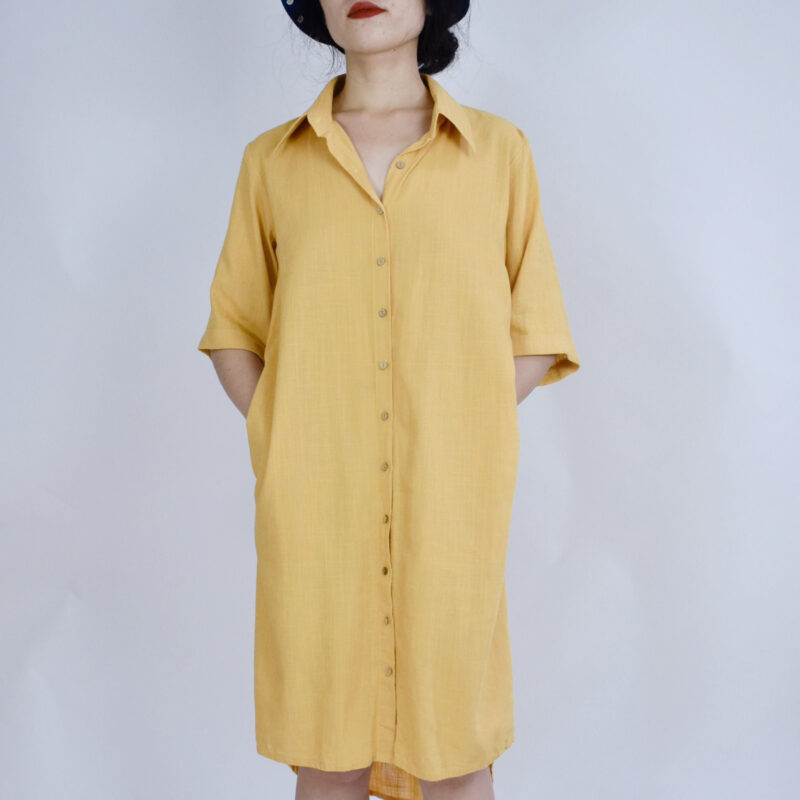 This soft yellow linen shirt dress embraces summer’s ease with its breathable natural fibers and minimalist silhouette. Featuring a classic collar, button-down front, and mid-length sleeves, it offers a gentle structure that flatters without restricting. Hidden side pockets add function to form, perfect for daily strolls under golden sunshine.