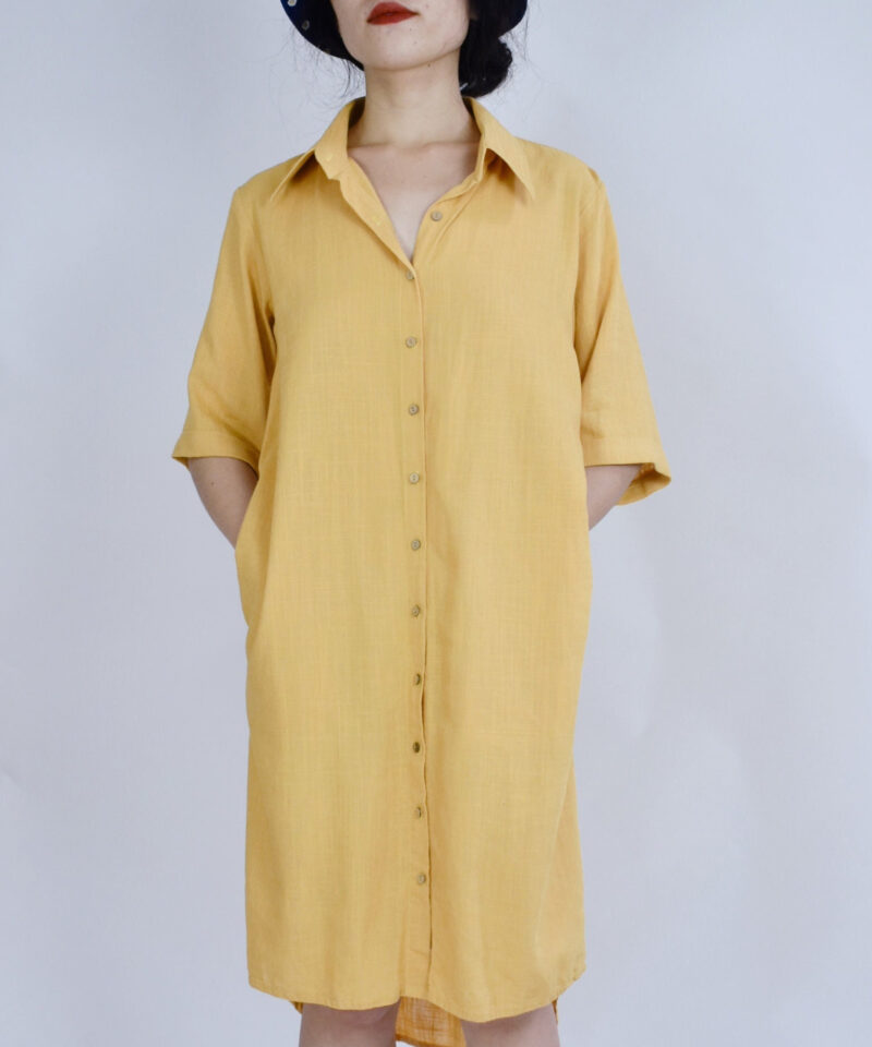 This soft yellow linen shirt dress embraces summer’s ease with its breathable natural fibers and minimalist silhouette. Featuring a classic collar, button-down front, and mid-length sleeves, it offers a gentle structure that flatters without restricting. Hidden side pockets add function to form, perfect for daily strolls under golden sunshine.