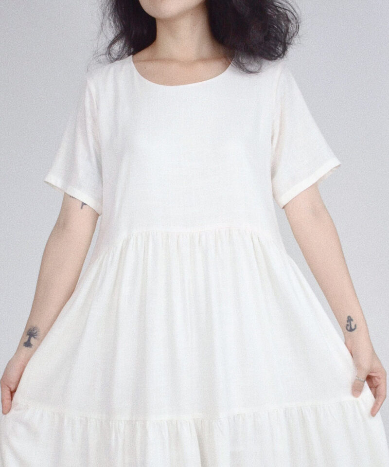 Crafted from 100% natural linen, this pure white dress features a soft tiered silhouette that flows effortlessly with every movement. The round neckline and short sleeves enhance its minimalist charm, making it perfect for warm-weather days or a slow-living, nature-inspired wardrobe.