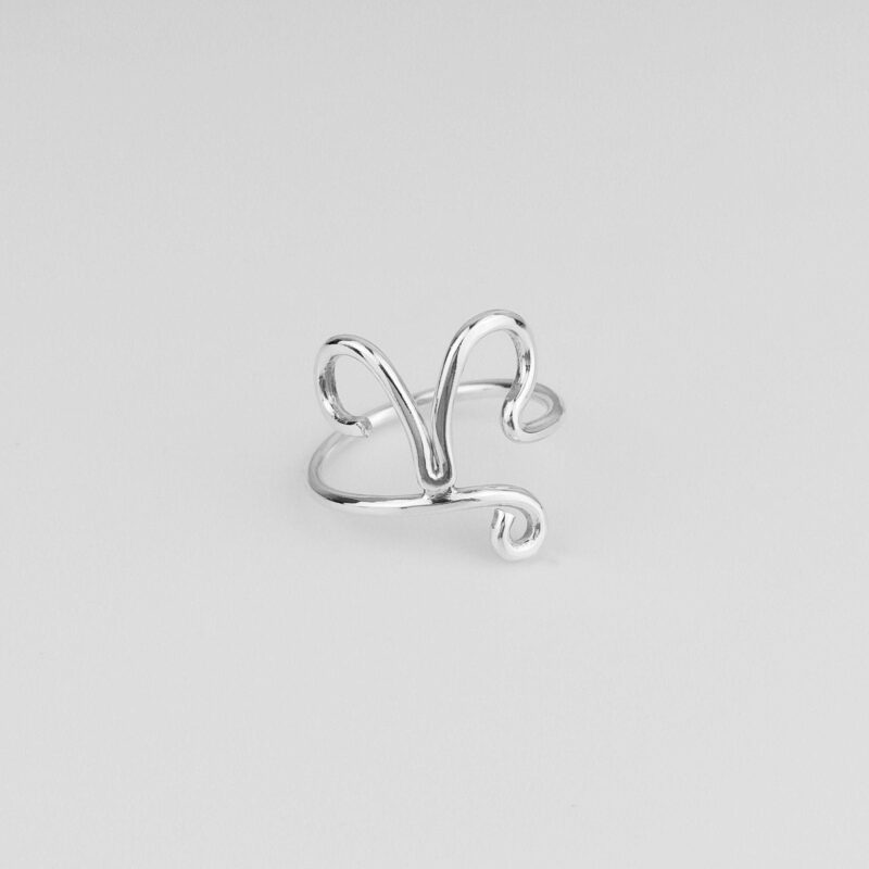 Close-up image of a handmade sterling silver Aries ring featuring the zodiac’s iconic ram horns in a minimalist open-band style. The smooth, high-polish finish enhances the refined shape, symbolizing passion and independence. Captured on a white background to highlight the intricate silver wirework and elegant craftsmanship, ideal for personalized gifts or everyday wear.