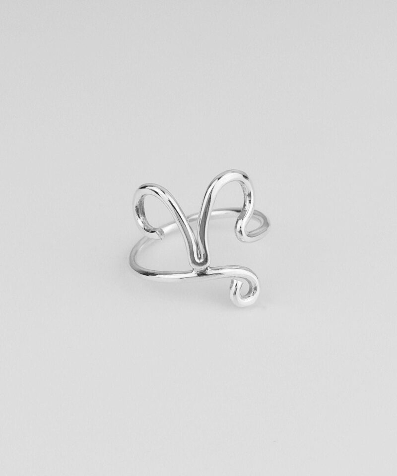 Close-up image of a handmade sterling silver Aries ring featuring the zodiac’s iconic ram horns in a minimalist open-band style. The smooth, high-polish finish enhances the refined shape, symbolizing passion and independence. Captured on a white background to highlight the intricate silver wirework and elegant craftsmanship, ideal for personalized gifts or everyday wear.