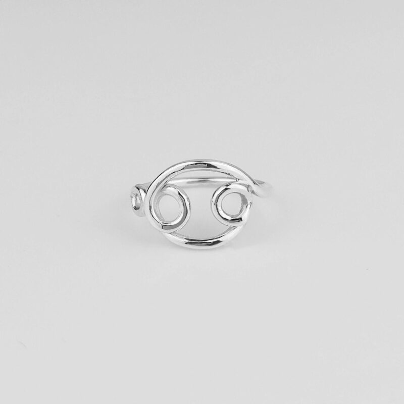 Close-up of a handcrafted Cancer zodiac ring made from polished 925 sterling silver. The ring features an open-style Cancer symbol design with smooth curves and balanced symmetry, showcasing the minimalist aesthetic and astrological symbolism. Ideal for astrology lovers and meaningful jewelry collectors.