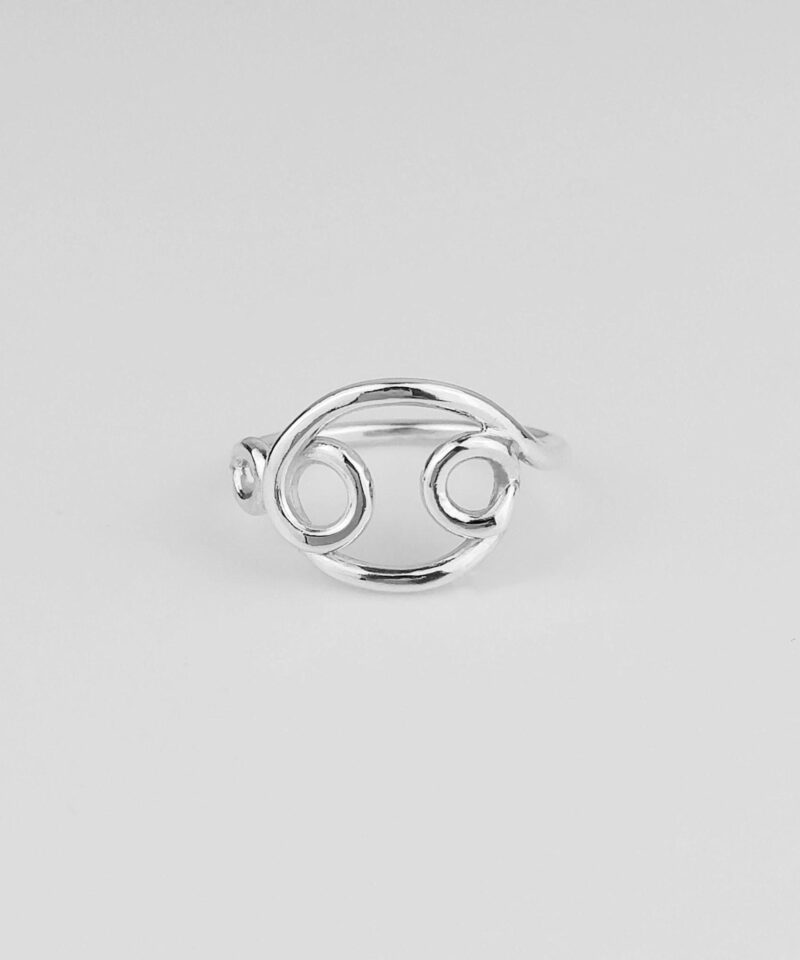 Close-up of a handcrafted Cancer zodiac ring made from polished 925 sterling silver. The ring features an open-style Cancer symbol design with smooth curves and balanced symmetry, showcasing the minimalist aesthetic and astrological symbolism. Ideal for astrology lovers and meaningful jewelry collectors.