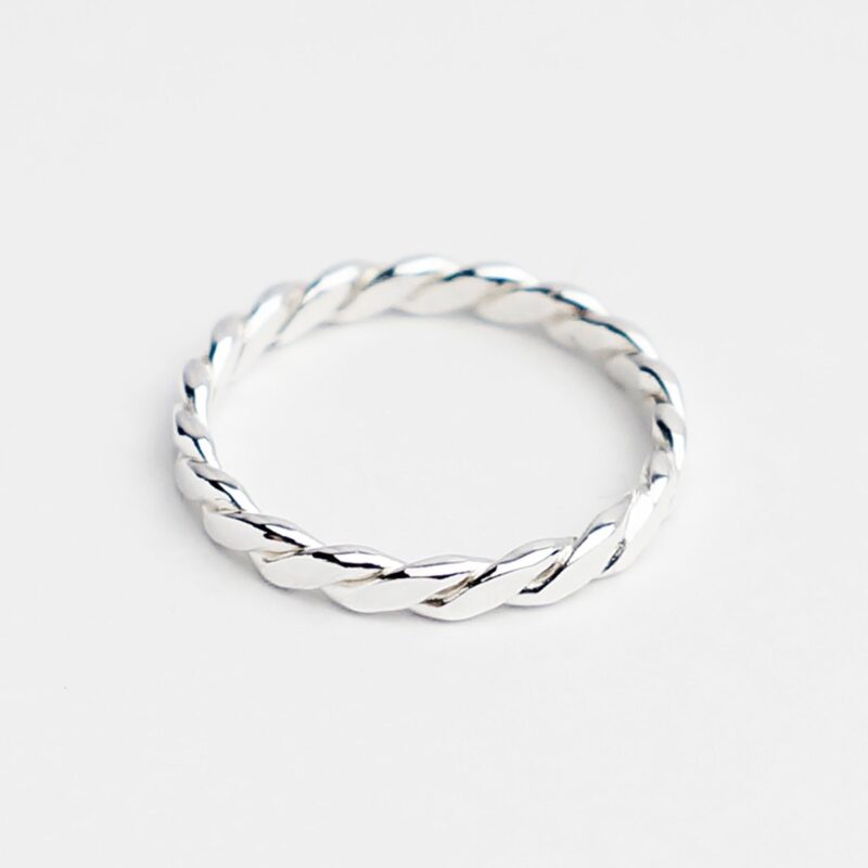 A minimalist classic twisted ring crafted in high-polish 925 sterling silver, featuring an elegant rope-like texture. The smooth twisted band reflects light beautifully and adds subtle detail to a simple silhouette. Perfect as a stacking ring or dainty daily accessory, its design embodies understated charm and timeless craftsmanship.