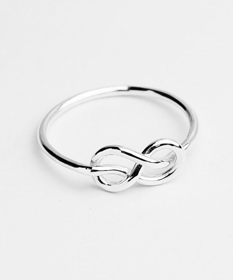 A delicate 925 sterling silver ring featuring a minimalist infinity knot design — symbolizing eternal love and deep connection. The polished surface catches the light gently, adding subtle charm to its slender band. Ideal for everyday wear, promise gifts, or layered stacking with other dainty rings.