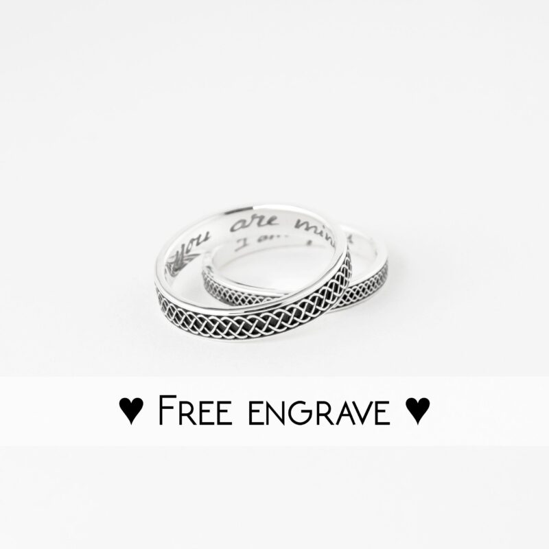 Flat lay of 925 sterling silver Celtic knot rings on white, with "you are mine" and "I am yours" engravings inside. Braided pattern stands out, perfect for couples wanting personalized promise or wedding rings with a heartfelt touch.