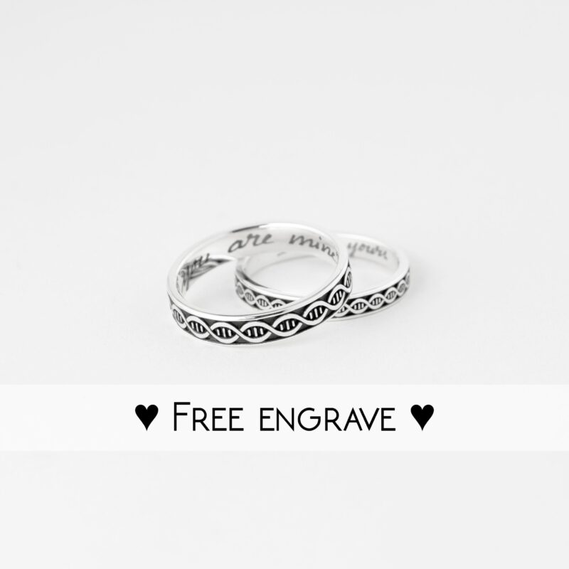 Studio shot of the DNA pattern silver couple rings placed together with “Free Engrave” text overlay. The focus is on the crisp, oxidized design and clean polish of each ring. Personalized engraving inside adds extra meaning, making them a perfect custom gift for anniversaries or promises between lovers.