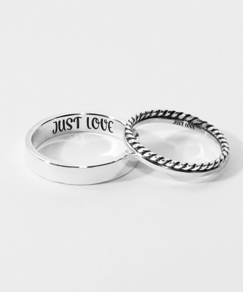 A beautiful set of two 925 sterling silver couple rings displayed on a white background. The thicker band has a simple polished finish with "JUST LOVE" engraved inside, while the thinner band features a charming twisted rope design. Both rings symbolize a timeless and meaningful connection between lovers, crafted with minimalist elegance for daily wear or special occasions.