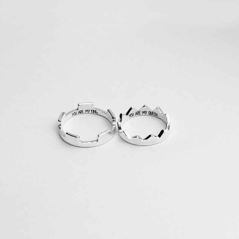 A pair of 925 sterling silver rings designed in the shape of royal crowns, one engraved with "YOU ARE MY KING" and the other with "YOU ARE MY QUEEN" on the inside. Set against a clean, minimal white background, these rings symbolize deep love and mutual respect in a relationship. The unique crown shapes make each ring feel regal and personal, perfect for couples who want to express their bond in a meaningful and stylish way.