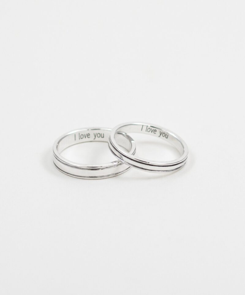 A delicate pair of 925 sterling silver minimalist rings displayed side by side on a clean white background. Each ring features a classic polished band design with a single fine line running around the center, offering a timeless and understated look. Inside the rings, the engraving 