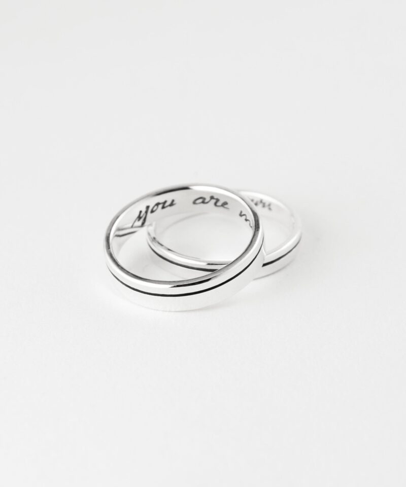 Product photography of a sterling silver ring with 'you are mine' custom engraving inside the band. The image displays the ring against a white background with a sample of the handwritten text above it for customization reference. Precise measurements show the ring is 4.5mm in width and 1.4mm in thickness. The polished silver band features a distinctive center groove design that runs around the exterior circumference, creating an elegant contemporary look.
