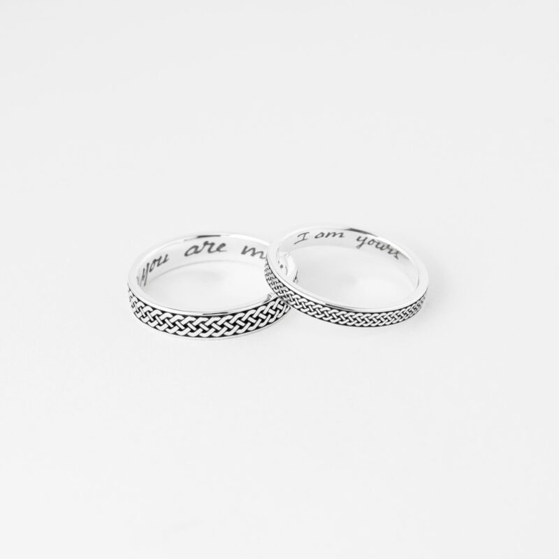 Two 925 sterling silver Celtic knot couple rings on white background. Intricate braided pattern shines, with engravings "you are mine" and "I am yours" inside. Perfect for a promise, engagement, or wedding gift with timeless symbolism.