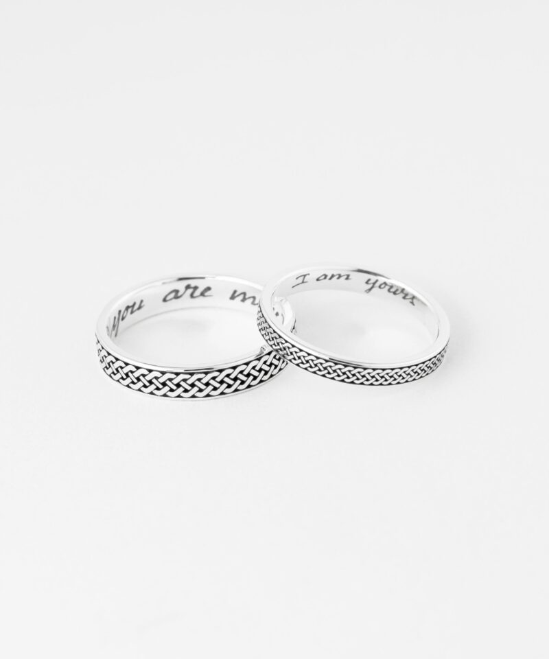 Two 925 sterling silver Celtic knot couple rings on white background. Intricate braided pattern shines, with engravings "you are mine" and "I am yours" inside. Perfect for a promise, engagement, or wedding gift with timeless symbolism.