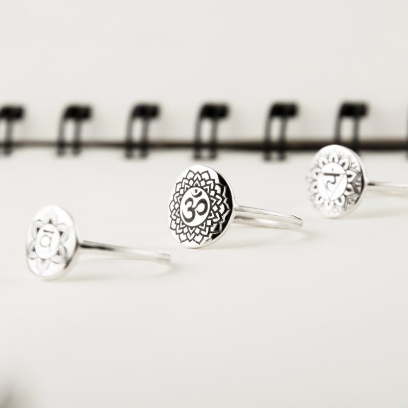 Sterling silver chakra ring featuring the Sahasrara symbol (crown chakra) engraved in high relief on a round signet surface. The polished band and geometric mandala border enhance the intricate Om symbol at the center. Ideal for spiritual healing, meditation, and energy balancing practices. This handmade ring is a meaningful gift for yogis, reiki practitioners, and seekers of mindfulness and inner peace.