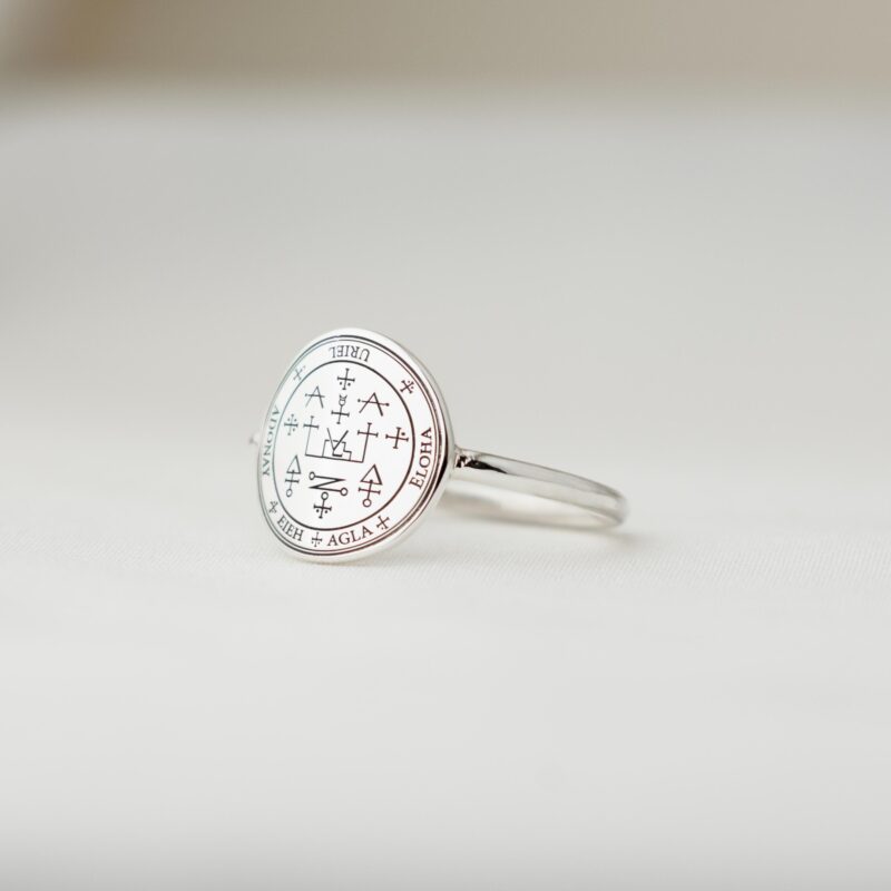 Side view of the Sigil of Archangel Uriel Silver Ring on a white surface, clearly showing the thickness of the ring face and the slim 1.6mm band, with the sigil facing upwards.