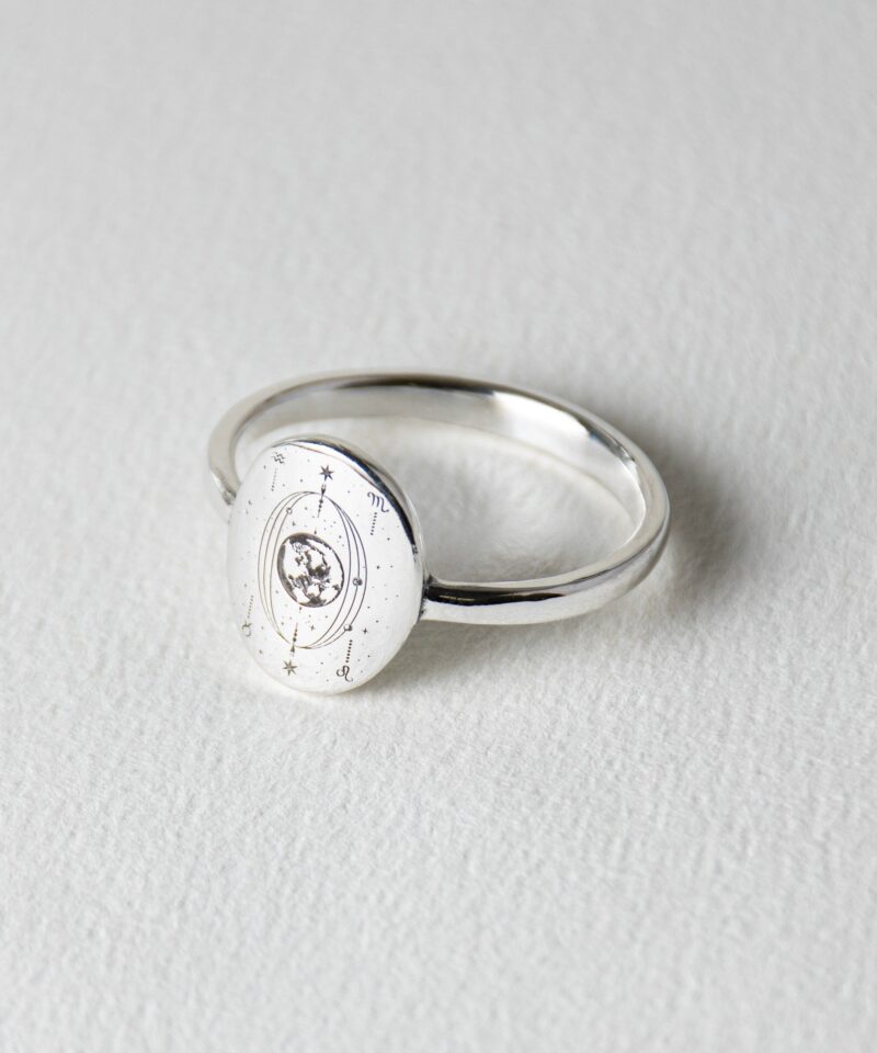 Minimalist 925 silver ring with a round face engraved with The World tarot card orbit, enhanced with a small white cubic zirconia stone in the center. The detailed constellation-inspired engraving includes planetary glyphs and radiating orbit lines, symbolizing the universe’s harmony and divine cycles. Perfect for spiritual seekers or cosmic jewelry collectors.