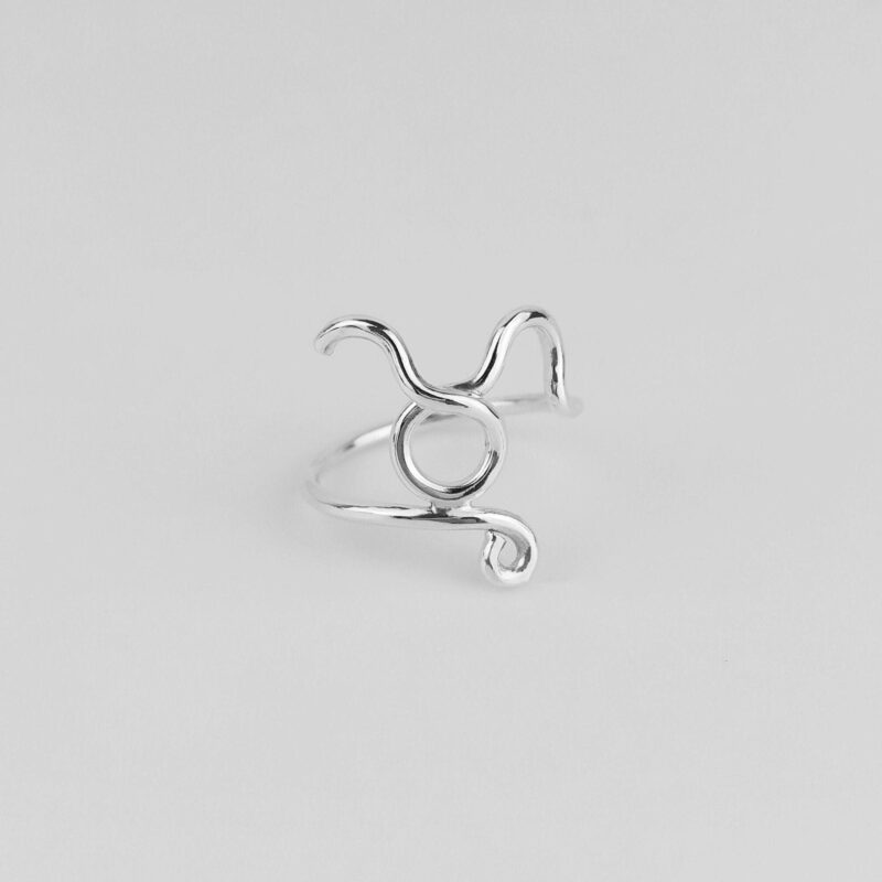 A minimalist Taurus sign ring in 925 sterling silver, photographed against a clean white background. The iconic bull symbol is shaped from a single line of silver with fluid motion, symbolizing grounded strength and calm persistence. Handcrafted for zodiac lovers who value subtlety and personal meaning in their accessories, this timeless piece adds a touch of celestial charm to any outfit.