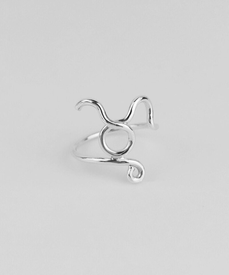 A minimalist Taurus sign ring in 925 sterling silver, photographed against a clean white background. The iconic bull symbol is shaped from a single line of silver with fluid motion, symbolizing grounded strength and calm persistence. Handcrafted for zodiac lovers who value subtlety and personal meaning in their accessories, this timeless piece adds a touch of celestial charm to any outfit.